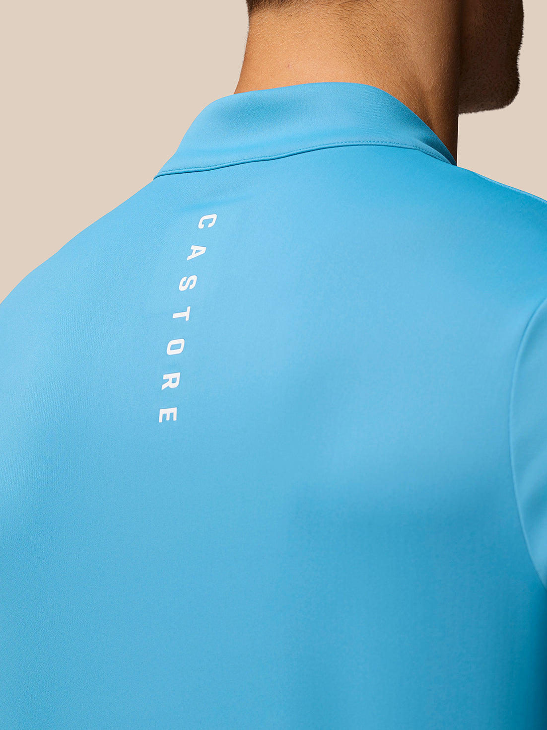 Back view of corn blue Club Golf 1/4 Zip Top with vertical Castore branding down the back