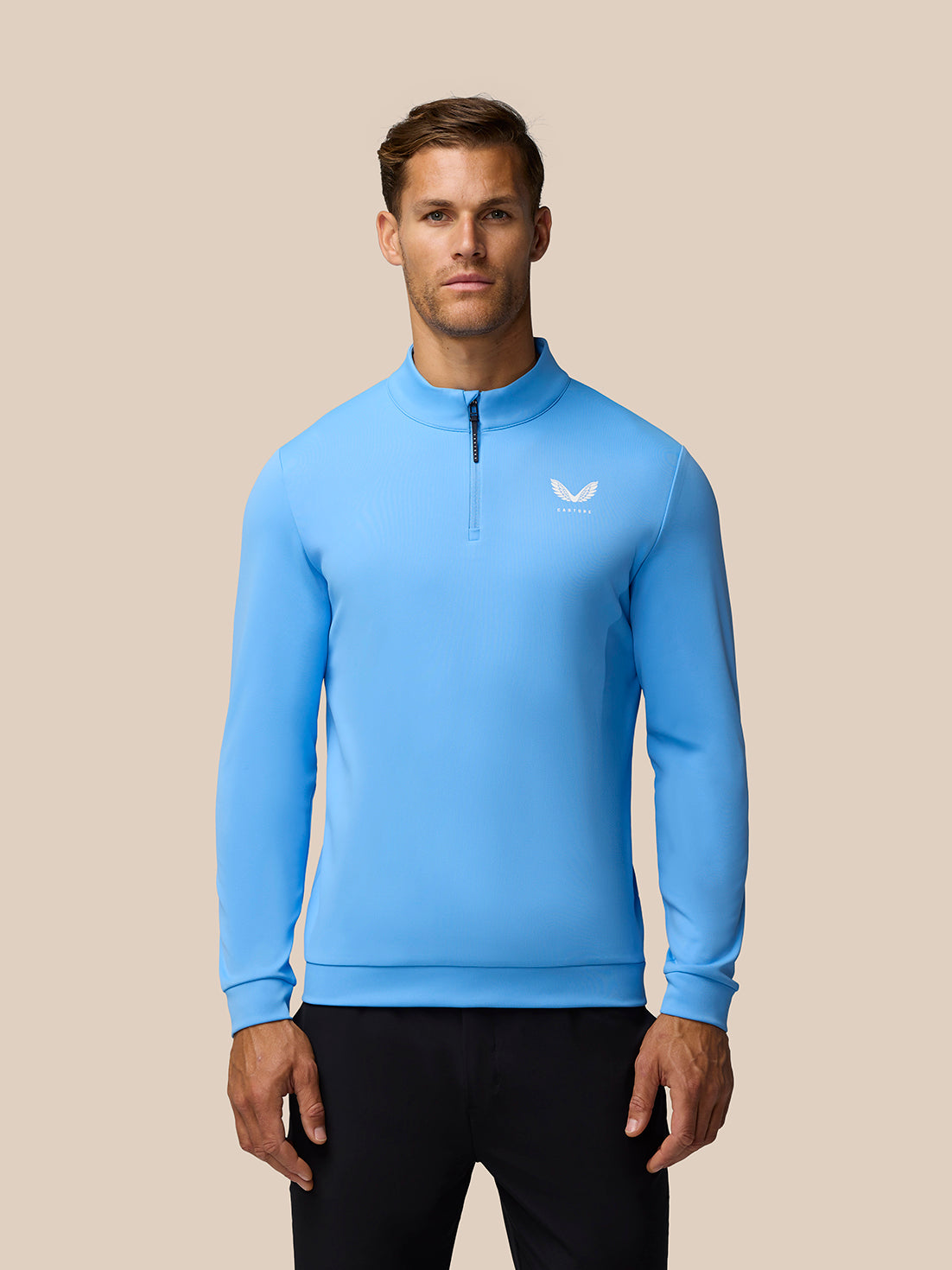 Male model wearing light blue Golf Club Classic quarter zip top with stand collar and small chest logo