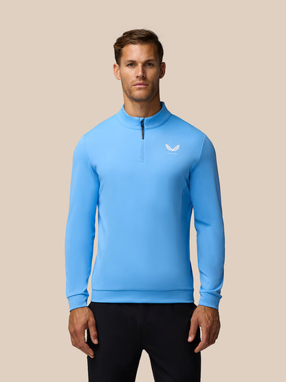 Male model wearing light blue Golf Club Classic quarter zip top with stand collar and small chest logo