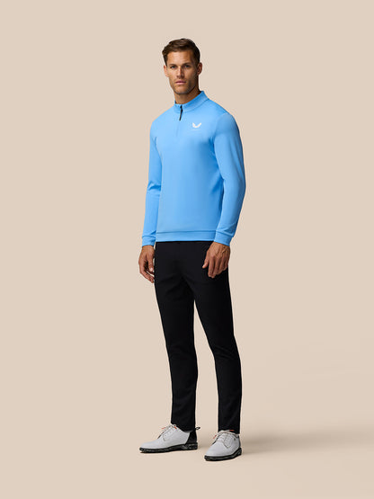 Front view of a man wearing a light blue Castore Golf Club Classic 1/4 Zip Top with a zip collar
