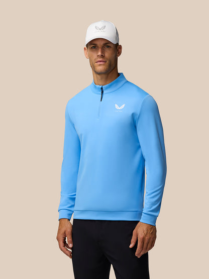Male model wearing Golf Club Classic Quarter Zip Top in Cool Blue with branded zip pull and left chest logo