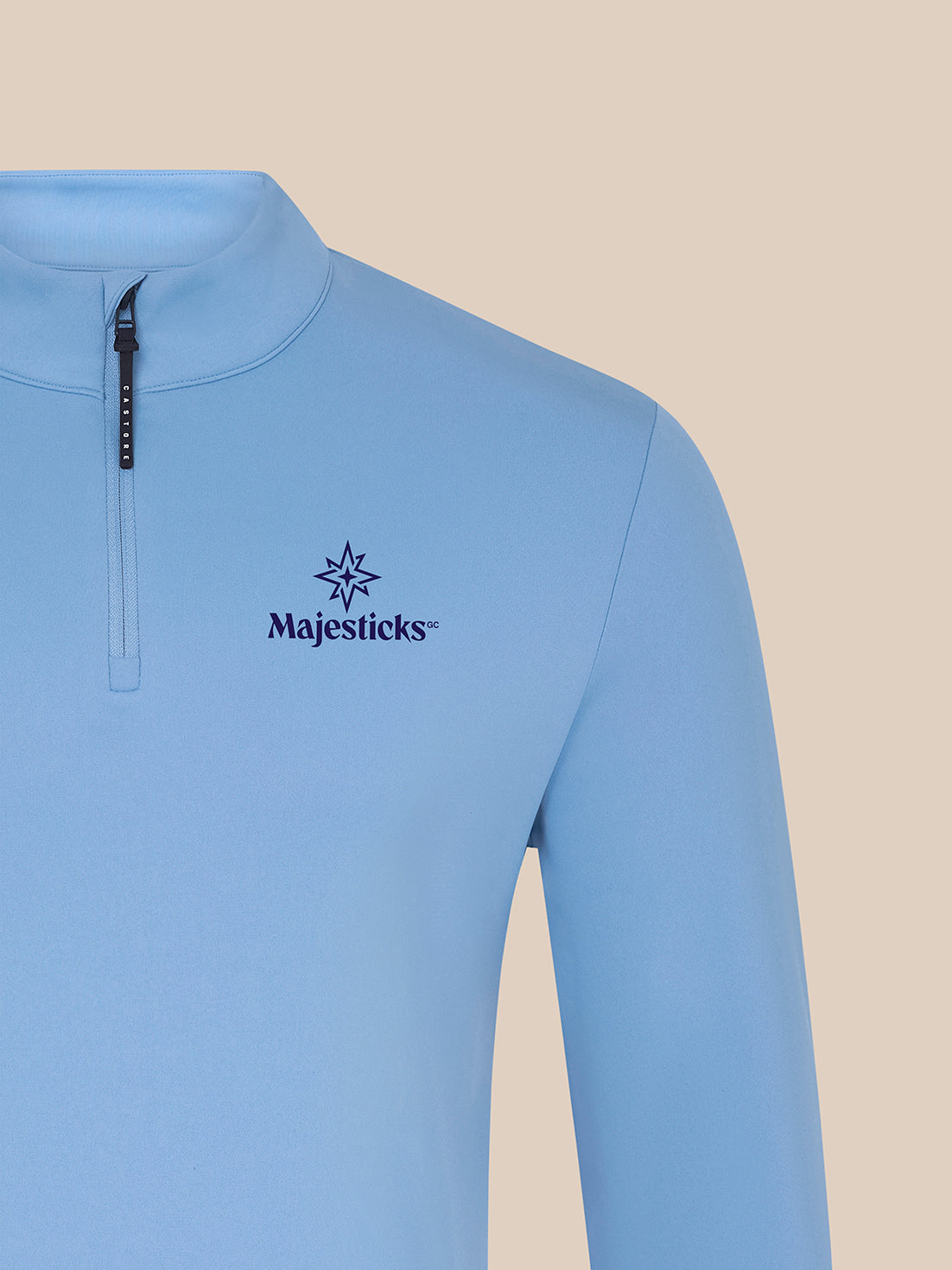 Close-up of sky blue Majesticks ¼ Zip Top left chest showing Majesticks logo.
