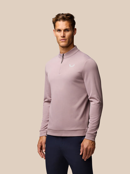 Male model in pink Club Golf 1/4 Zip Top with stand collar and quarter zip; white Castore logo on chest