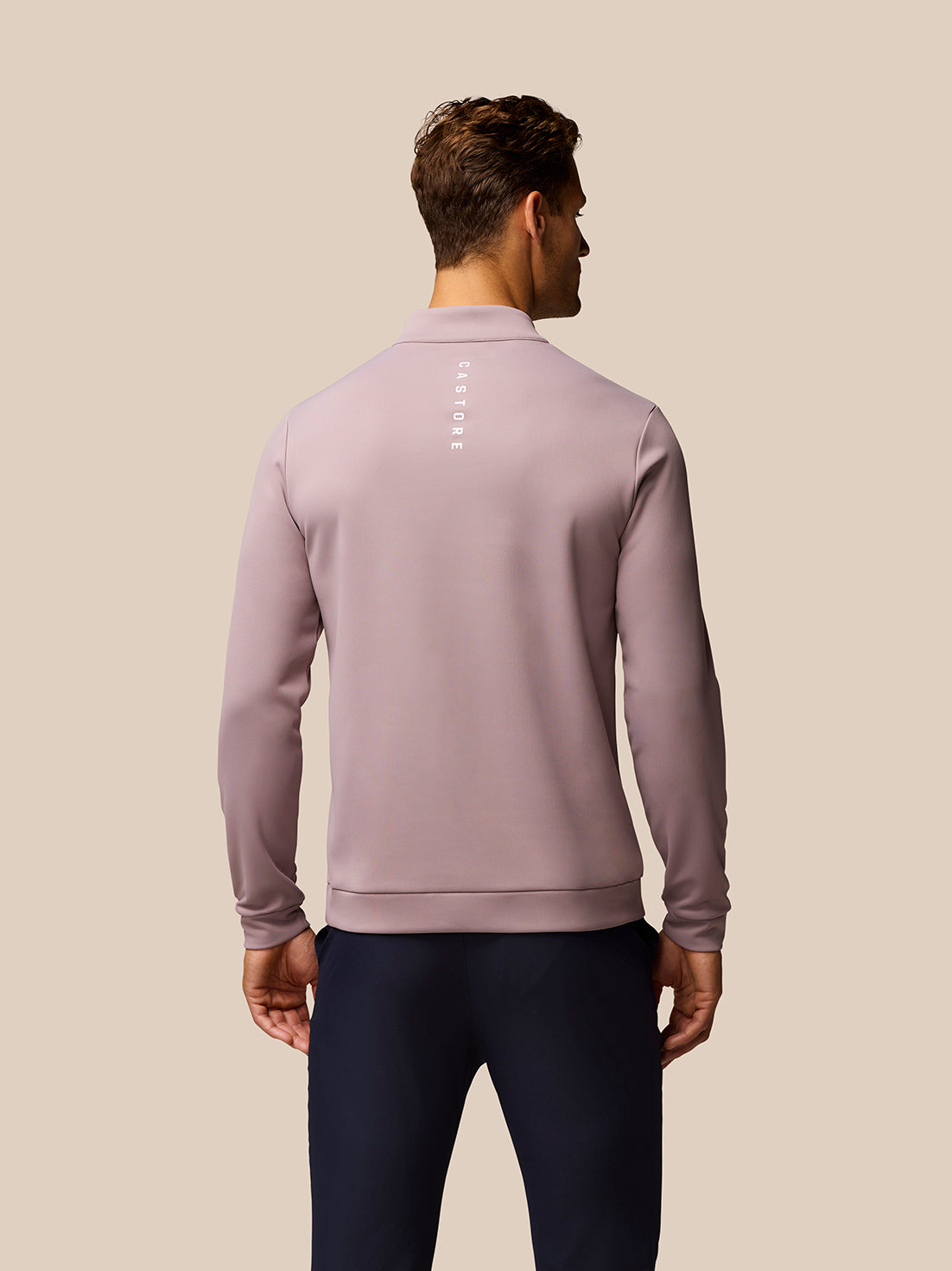 Back view of pink Club Golf 1/4 Zip Top with vertical Castore branding along the back