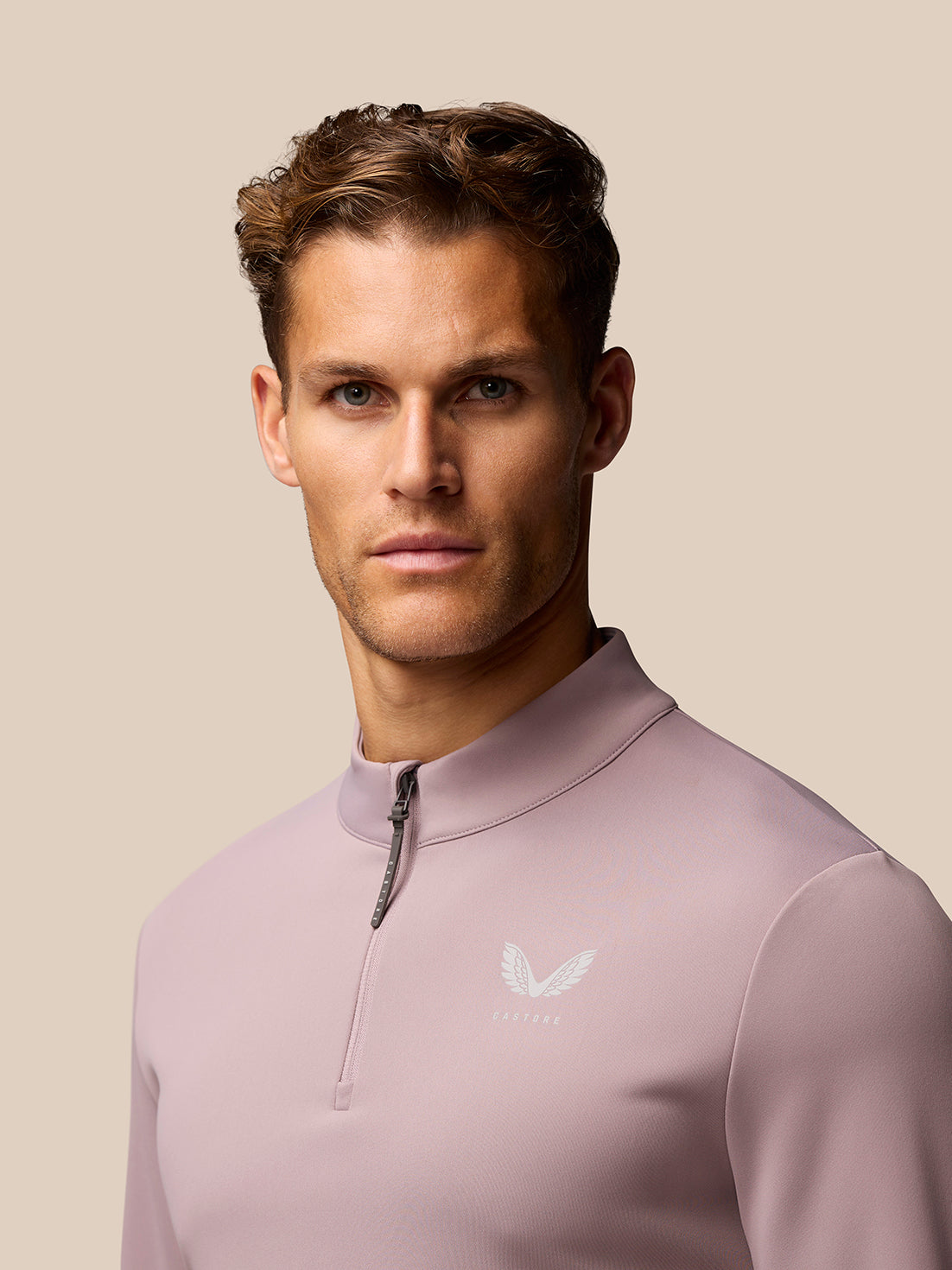 Male model wearing pink Club Golf 1/4 Zip Top with stand collar