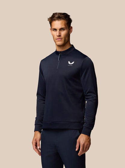 Male model in midnight navy golf club classic quarter zip top with stand collar and Castore logo.