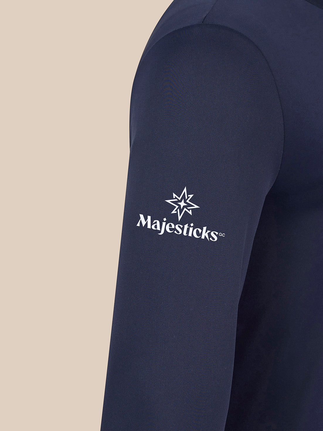 Close up of navy golf top sleeve with Majesticks logo and star emblem
