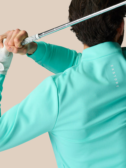 Golfer in light aqua Golf Club Classic 1/4 Zip Top during swing, Castore logo visible on back