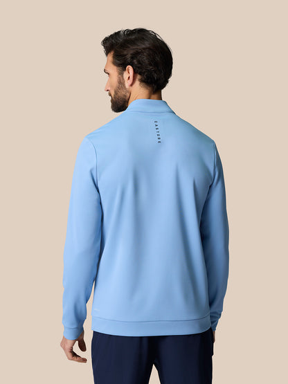 Back view of man wearing sky blue Golf Club Classic 1/4 Zip Top with Castore branding on upper back.