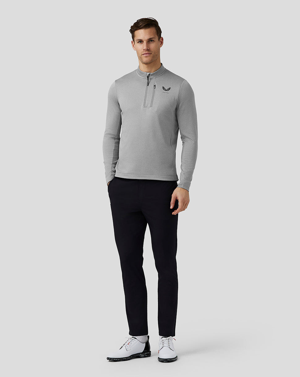 Full body shot of a man in steel Pinnacle Tech Half Zip Top with a chest zip and left chest logo