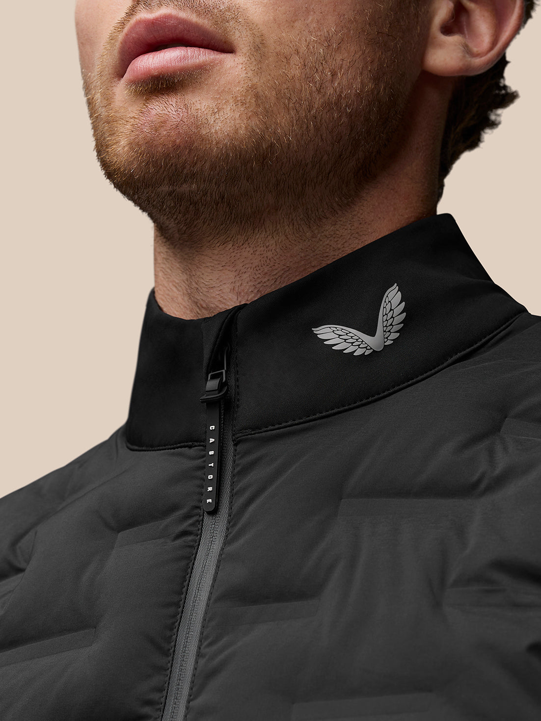 Close-up of a man wearing a black Golf Pinnacle Gilet with stand collar and logo at the collar