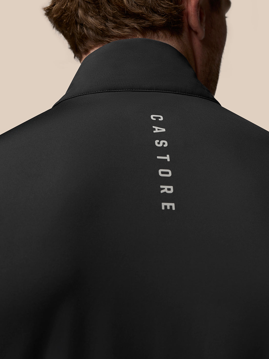 Back view close up of the black Pinnacle Gilet showing vertical CASTORE branding along the back of the collar.