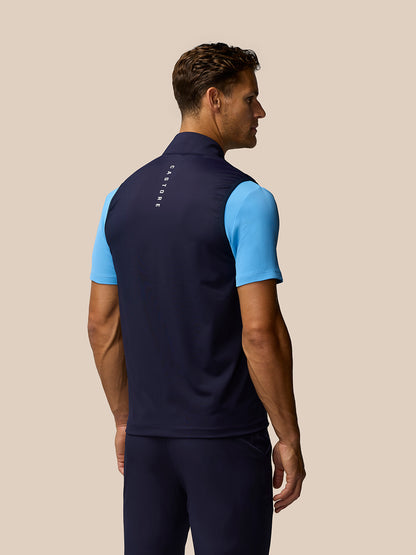 Rear view of male model in navy Pinnacle Gilet with Castore branding along the back
