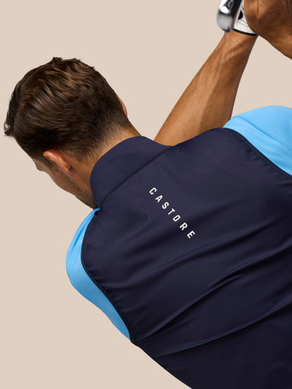 Back view of navy Pinnacle Gilet with light blue sleeves and CASTORE branding along the upper back.