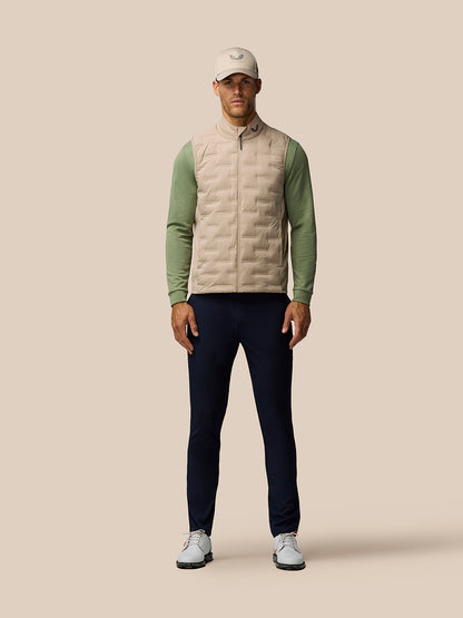 Front view of a male model wearing Mushroom Pinnacle Lightweight Hybrid Gilet with beige torso and green sleeves.