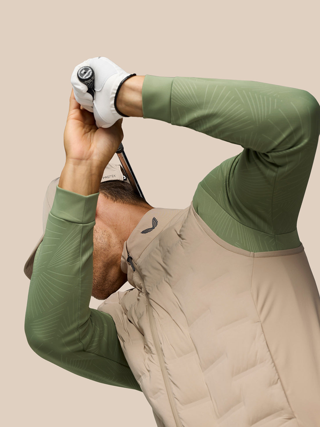 Male golfer wearing Mushroom Pinnacle Lightweight Hybrid Gilet with quilted front and ProTek water resistance.
