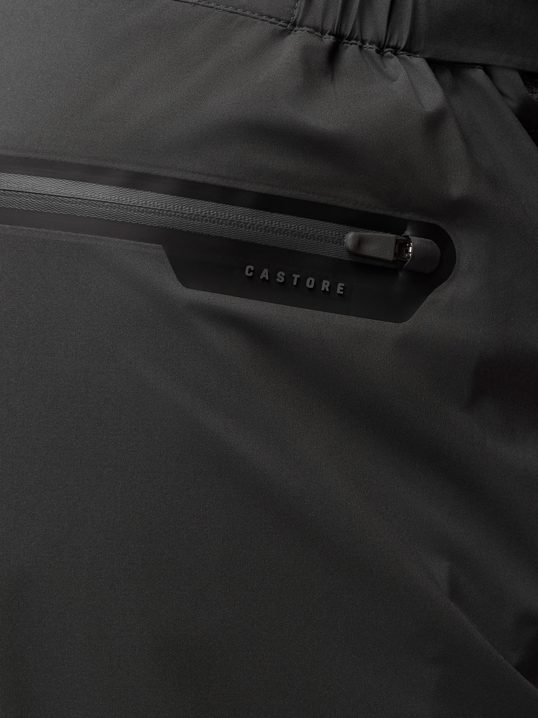 Close-up of leg zipper with ProTek branding on dark fabric