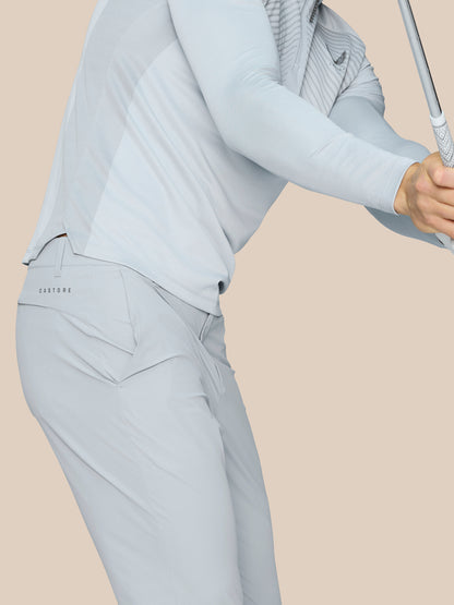 Male model wearing mid grey Castore Golf Pinnacle Trousers with a golf club.