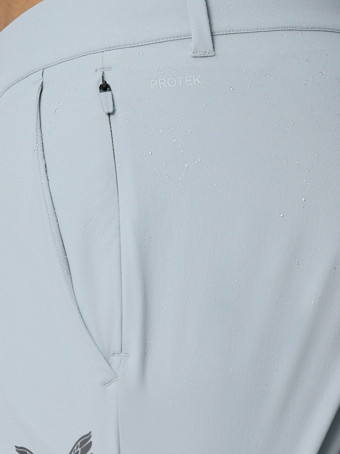 Close-up of the lower leg with cuff zip closure on light grey Golf Pinnacle Trousers showing water resistant fabric detail