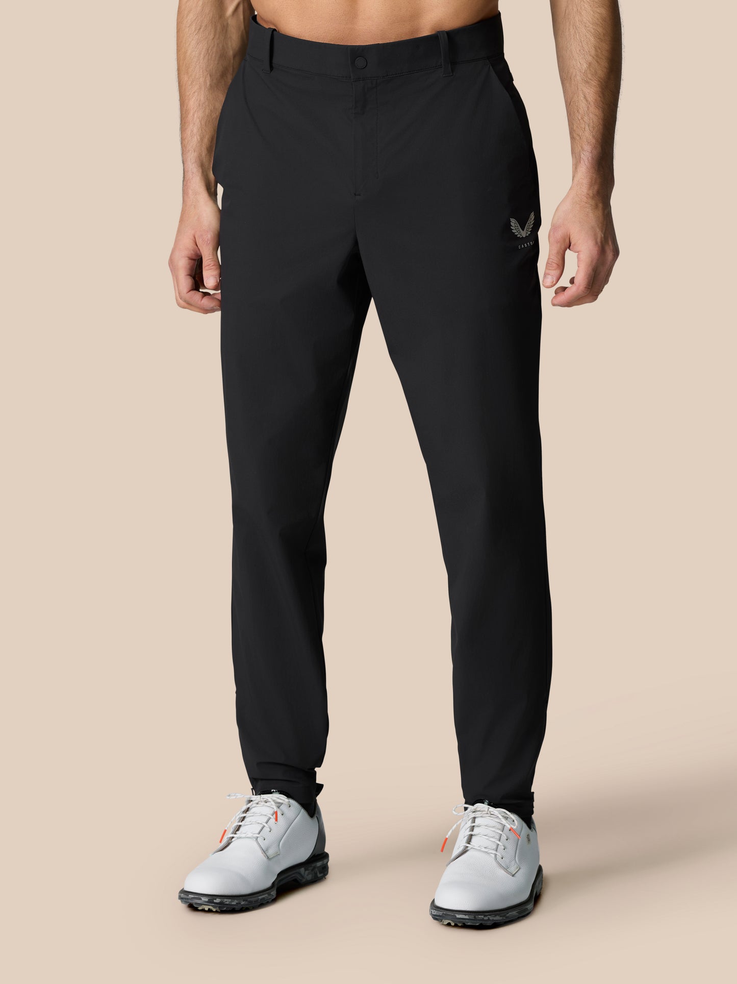 Close-up of black Golf Pinnacle Trousers focusing on waistband and Castore emblem on thigh