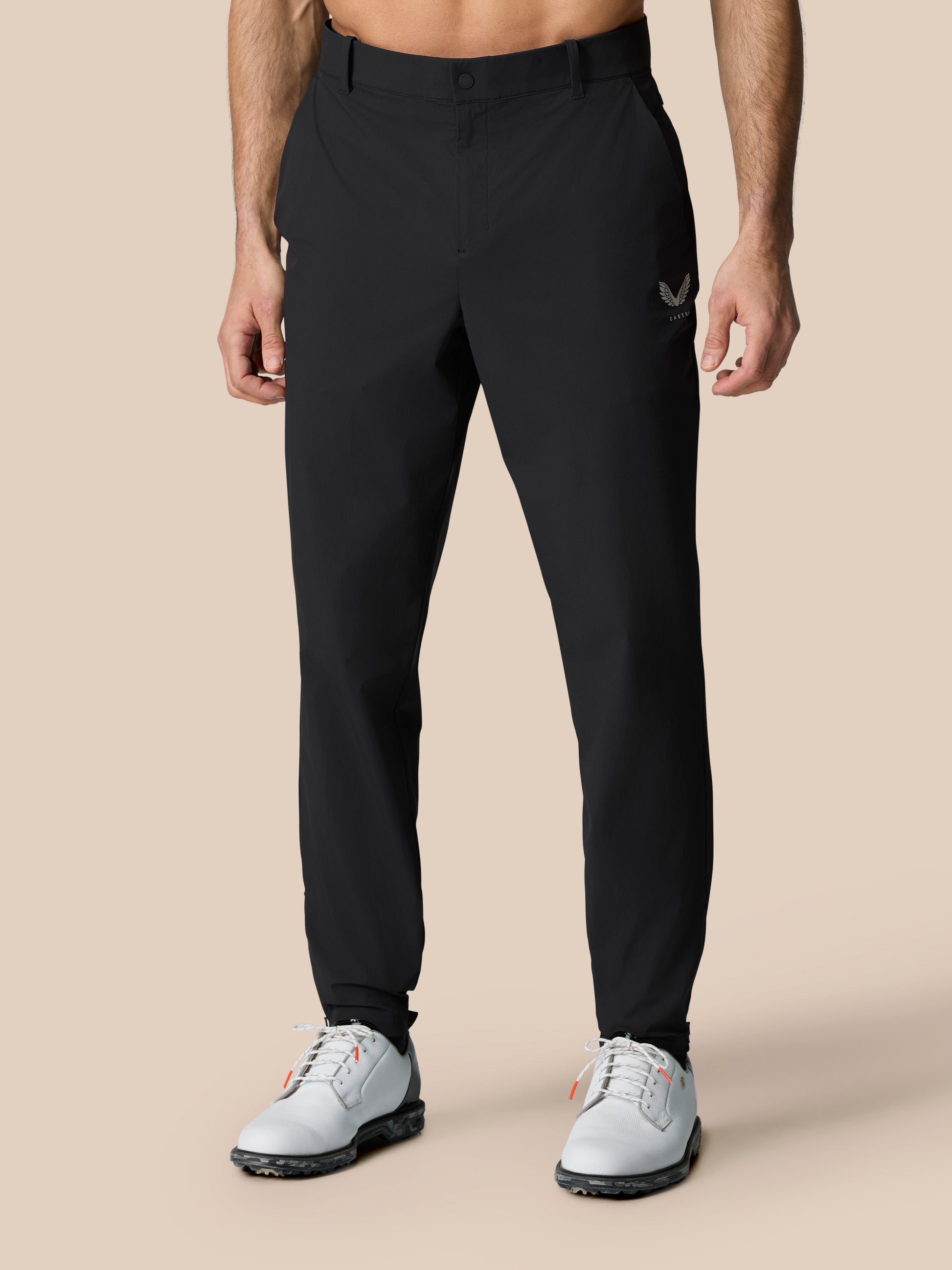 Close-up of black Golf Pinnacle Trousers focusing on waistband and Castore emblem on thigh