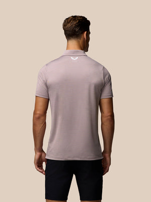 Model wearing light pink striped golf polo with short sleeves and white Castore logo on left chest