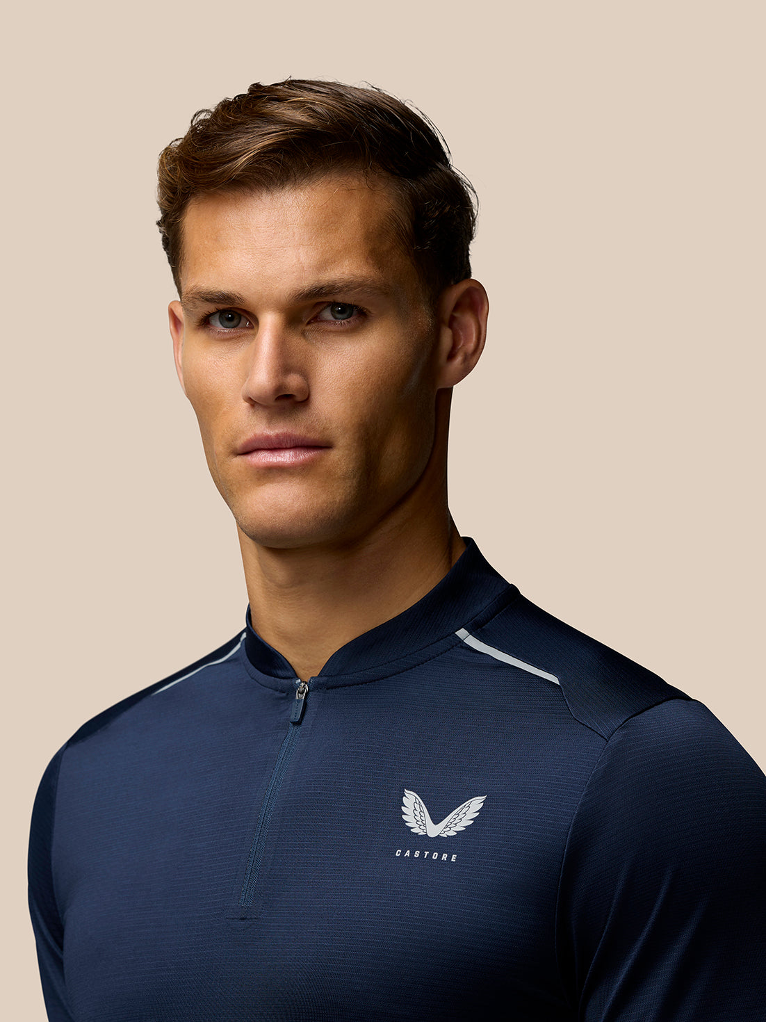 Rear-angle shot of navy Pinnacle Varsity Polo with Castore branding along the upper back