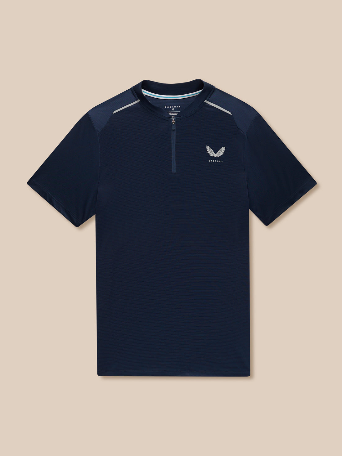 Flat-lay navy Pinnacle Varsity Polo with quarter zip and left chest logo against a beige background.