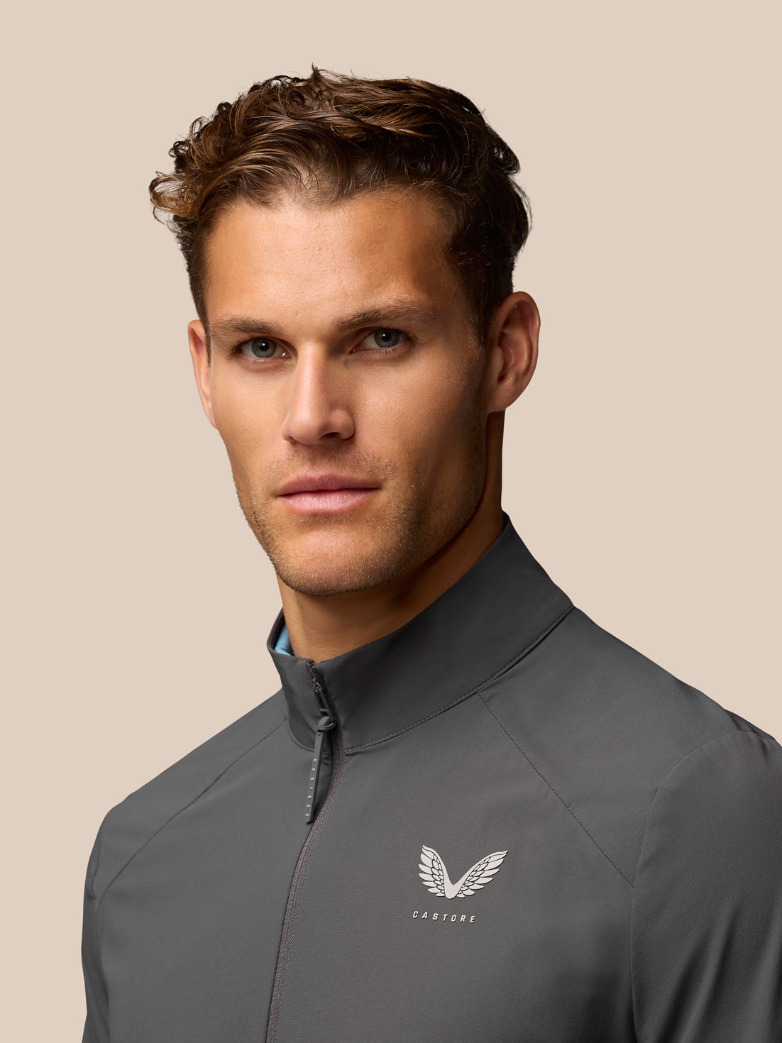 Close-up of charcoal Golf Half Zip Top with front zip and chest Castore branding.
