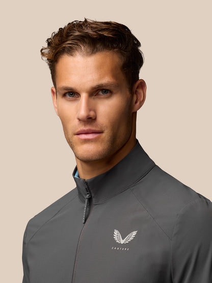Close-up of charcoal Golf Half Zip Top with front zip and chest Castore branding.