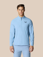 Model wearing sky blue Golf Flex Jacket with half zip at front and Castore logo on chest.
