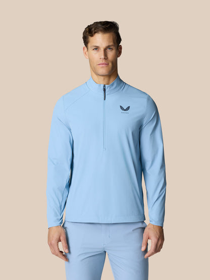 Model wearing sky blue Golf Flex Jacket with half zip at front and Castore logo on chest.