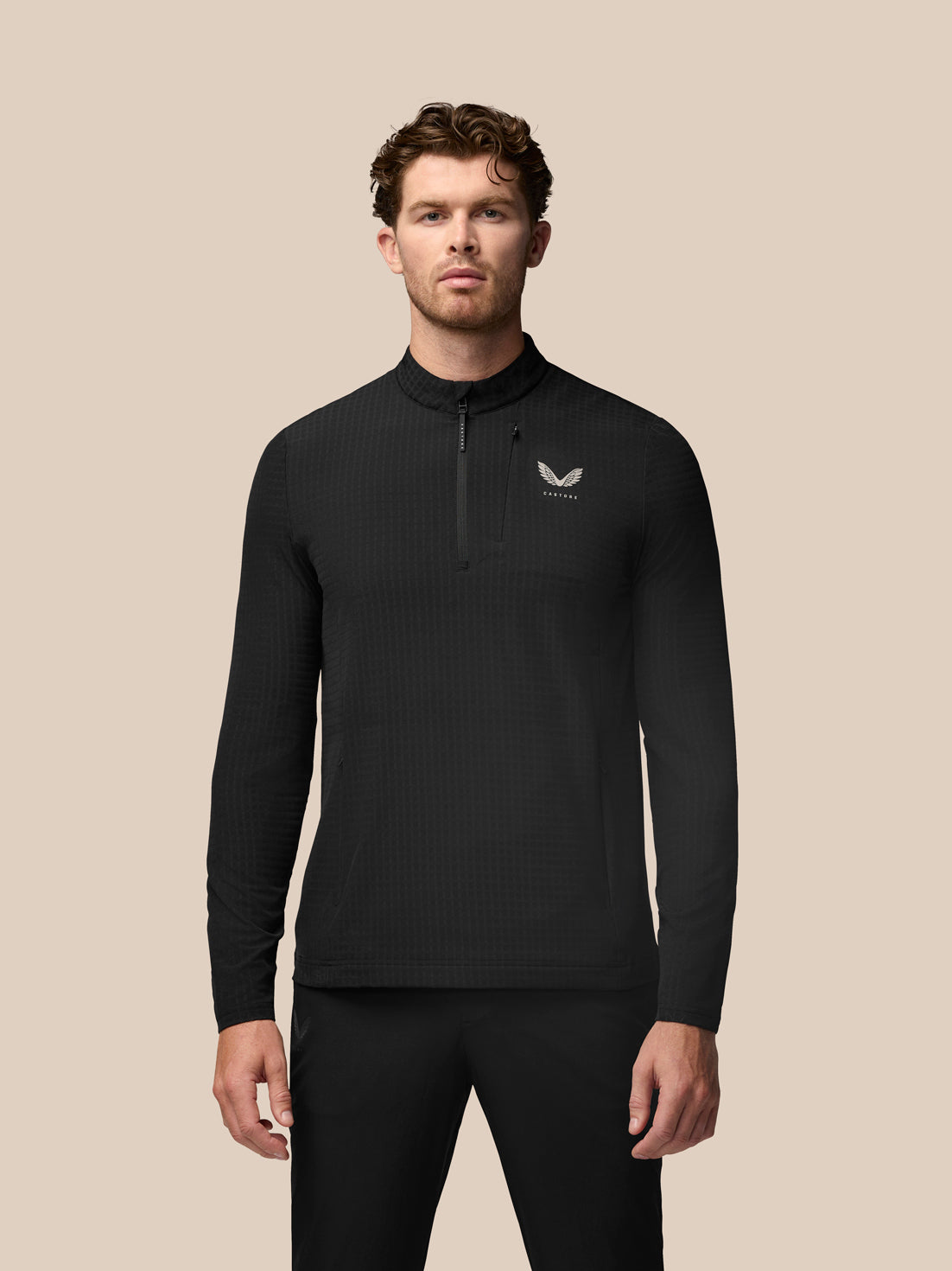 Model wearing black Golf 1/2 Zip Top with stand collar and front half zip, textured waffle fabric and water-resistant pocket zippers