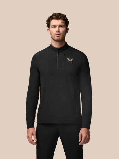 Model wearing black Golf 1/2 Zip Top with stand collar and front half zip, textured waffle fabric and water-resistant pocket zippers
