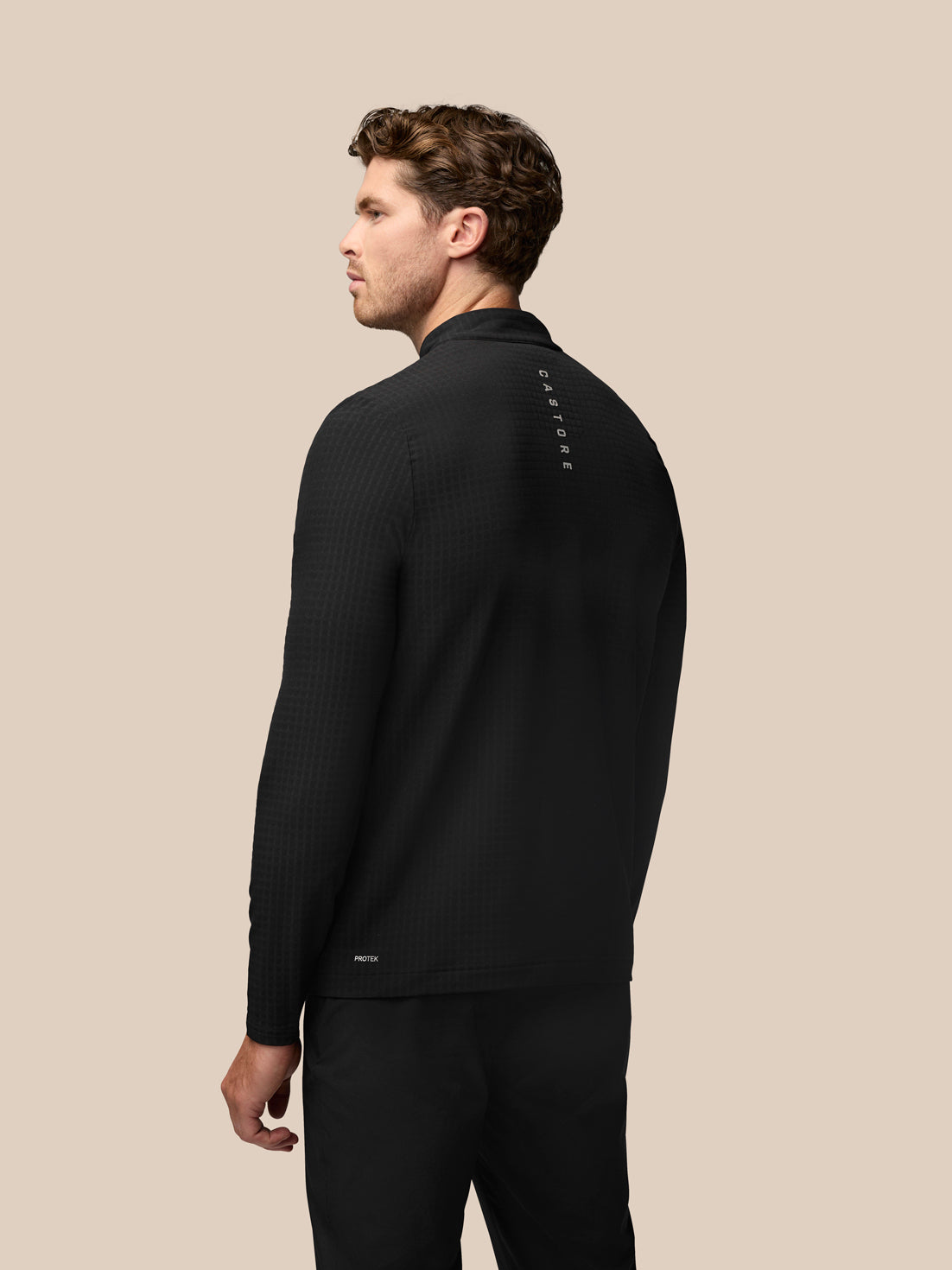 Back view of black Golf 1/2 Zip Top with waffle texture and Castore branding along the upper back