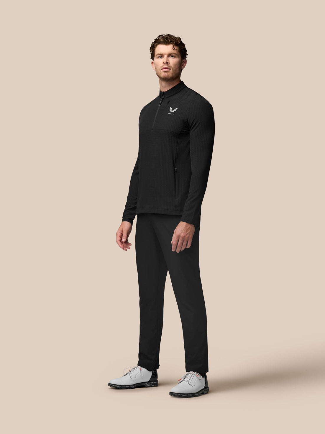 Side and back view of black Golf 1/2 Zip Top with waffle texture and vertical Castore branding on the back