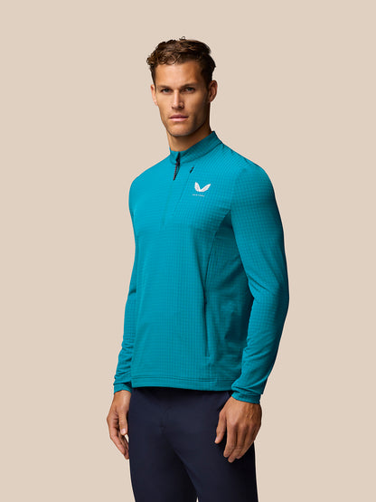 Blue Golf 1/2 Zip Top on a male model with stand collar long sleeves and front half zip, Castore branding on chest and back.
