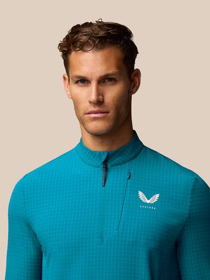 Close-up of turquoise Golf 1/2 Zip Top showing stand collar front half zip and chest logo