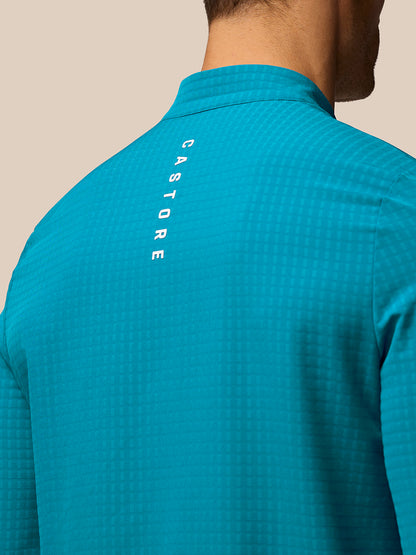 Back view of turquoise Golf 1/2 Zip Top with vertical CASTORE branding along the upper back