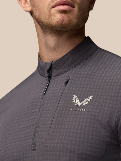 Detail view of the grey Golf 1/2 Zip Top with front zipper and Castore crest on the chest