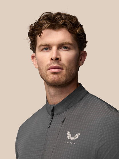 Male model wearing grey textured golf top with stand collar and Castore logo on chest