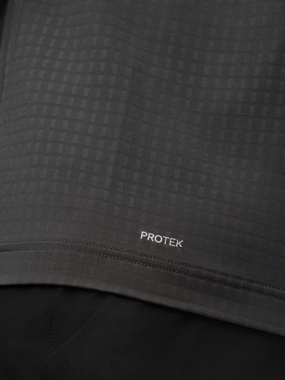 Close up of dark grey Protek fabric with subtle check pattern and Protek branding