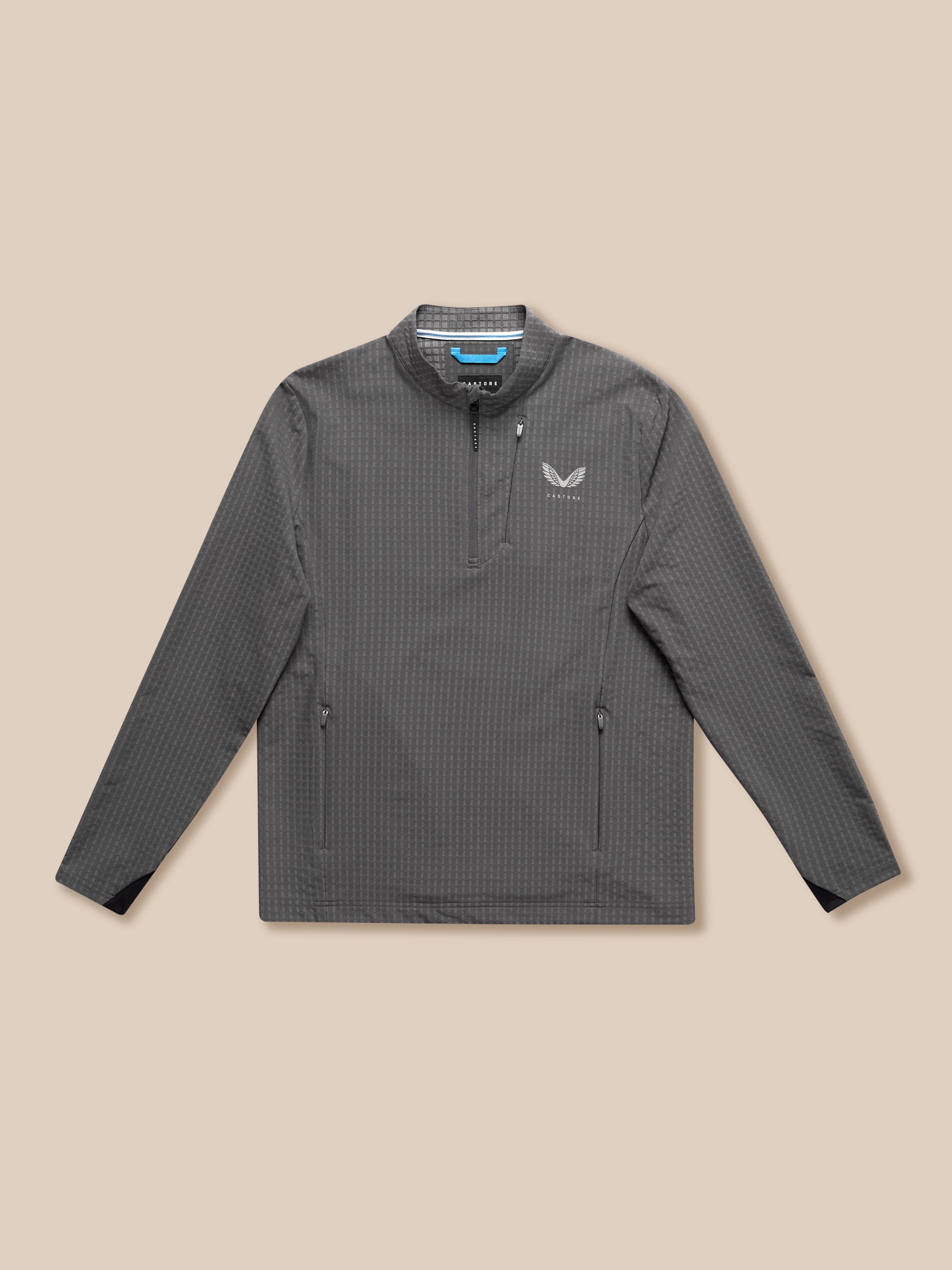Grey golf top with stand collar and half zip shown on beige background with Castore logo on chest