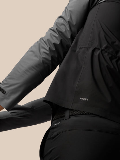 Close-up of gunmetal golf waterproof jacket showing two tone gray panels and Protek branding at the hem