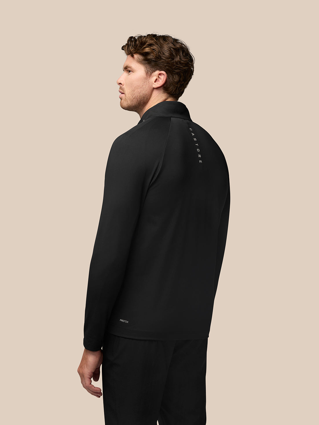 Back view of black Golf Pinnacle Jacket with vertical Castore branding down the back