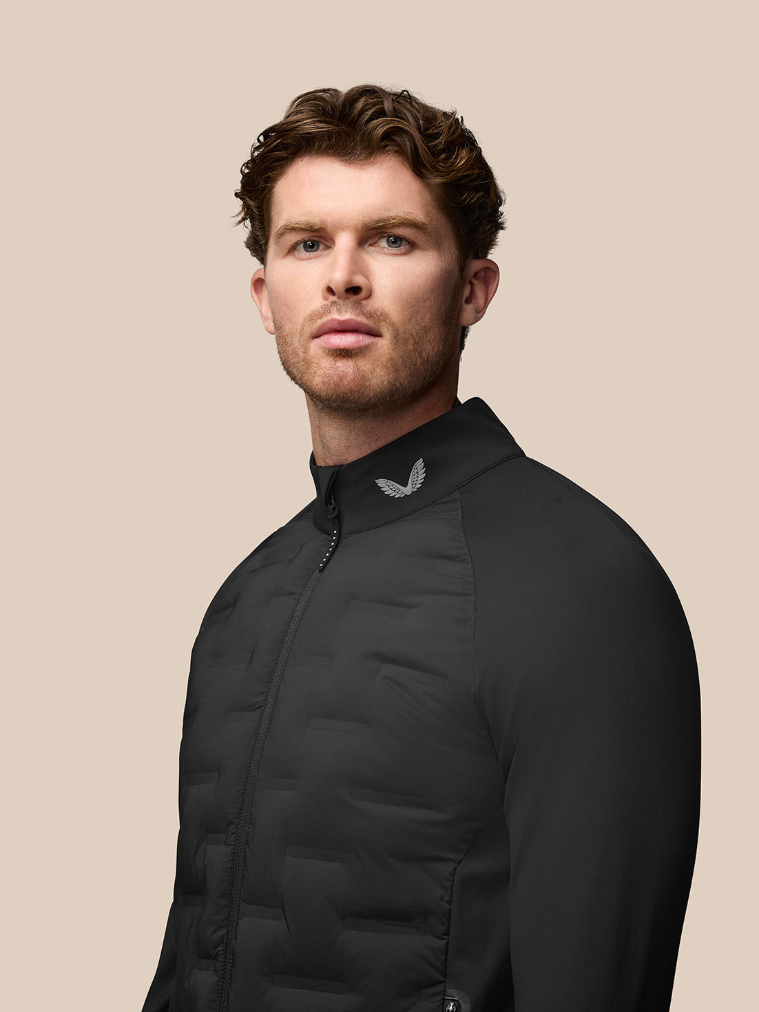 Male model wearing black Golf Pinnacle Jacket with stand collar and full zip