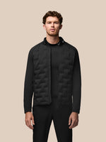 Male model wearing black Golf Pinnacle Jacket with quilted front panels and stand collar