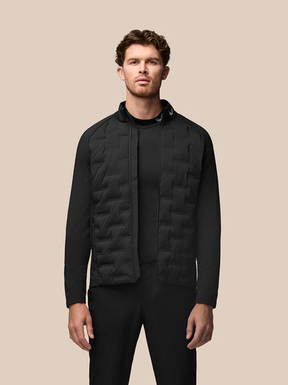 Male model wearing black Golf Pinnacle Jacket with quilted front panels and stand collar