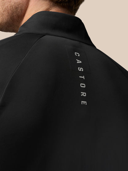 Back view of black Pinnacle Golf Jacket with vertical CASTORE lettering along the upper back