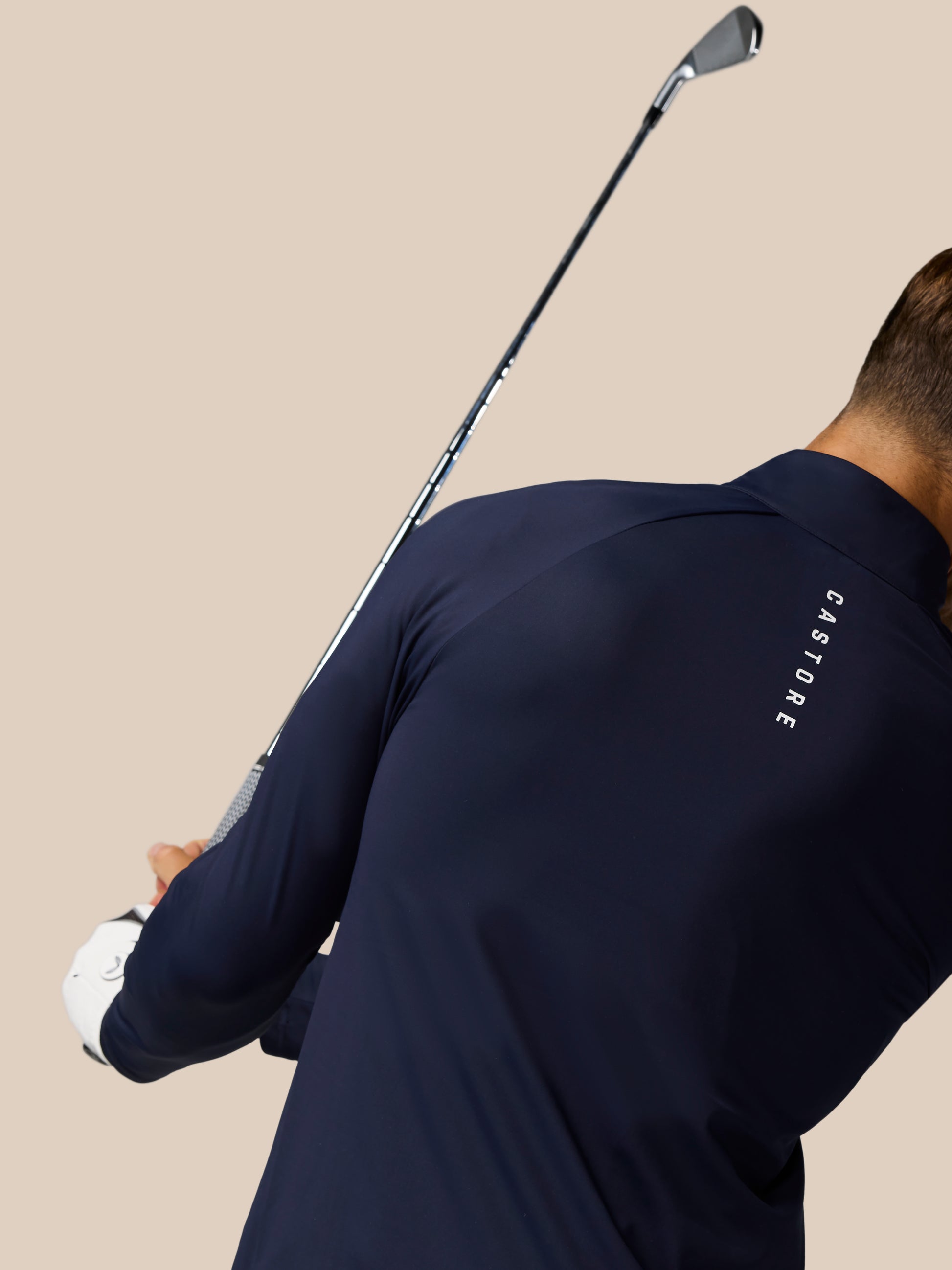 Back view of midnight navy Castore Golf Pinnacle Jacket showing branding along the shoulder area